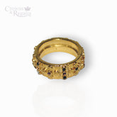 Gold ring with gemstones on a white background, branded 'Crowns & Regalia'.